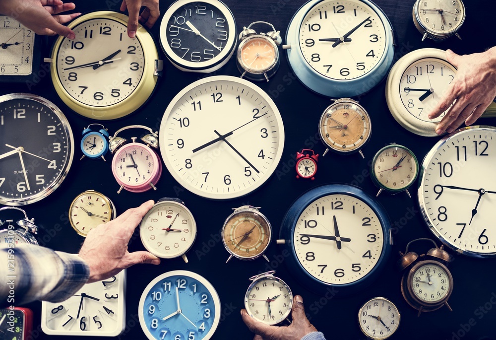 Hands holding various clocks