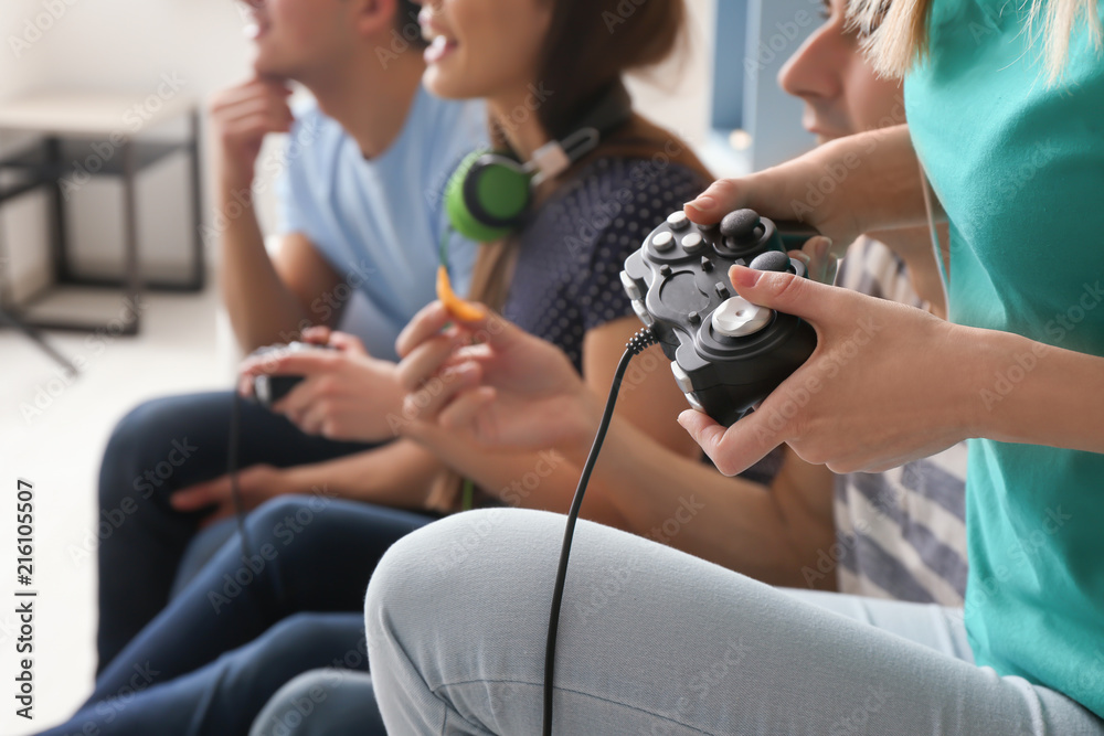 Young people playing video games at home, closeup