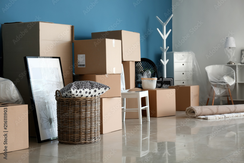 Carton boxes and interior items on floor in room. Moving house concept