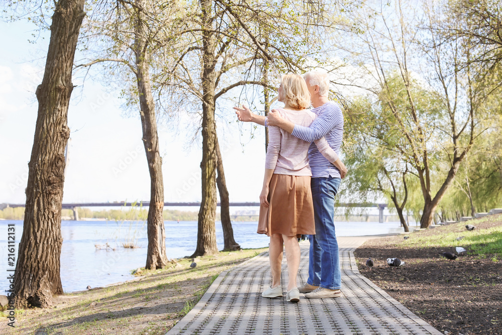 Mature couple walking in park on spring day