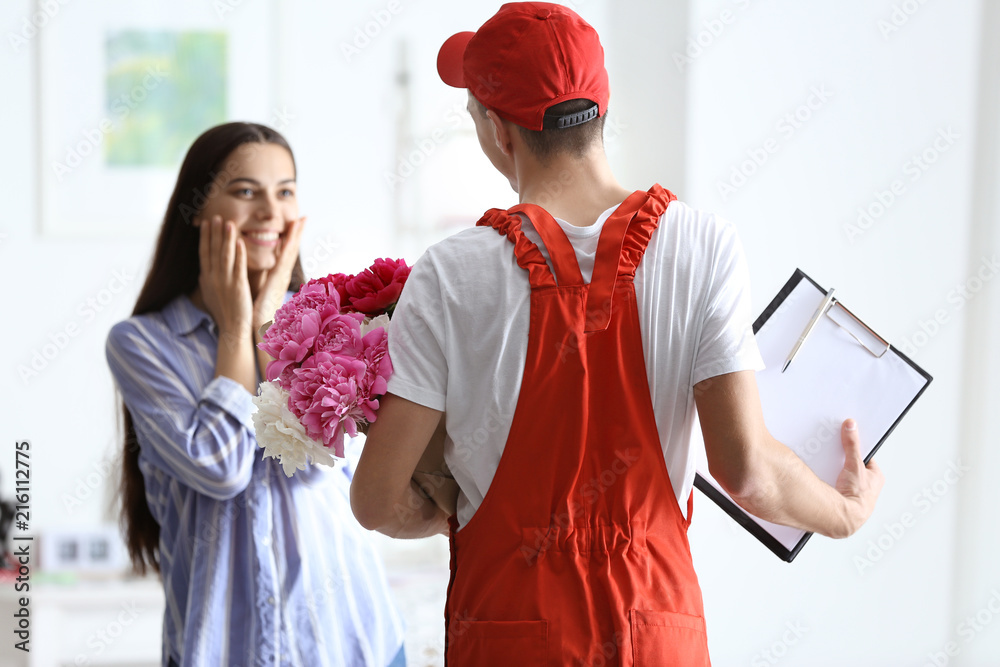 年轻女子从送餐员那里收到美丽的鲜花