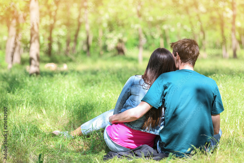 Happy young couple resting in green park