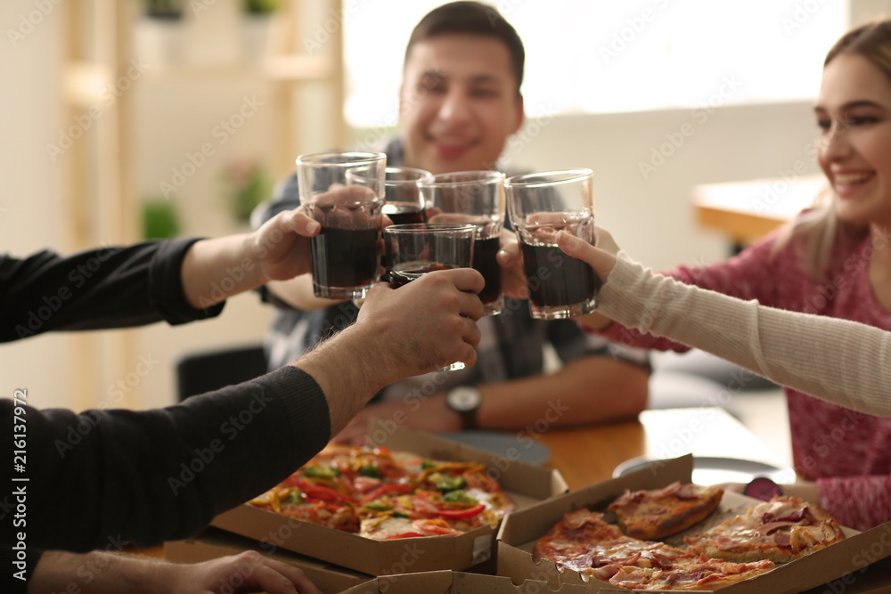 年轻人在室内桌子上碰杯