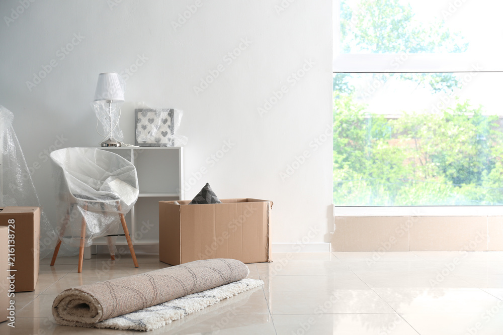 Carton boxes and interior items on floor in room. Moving house concept