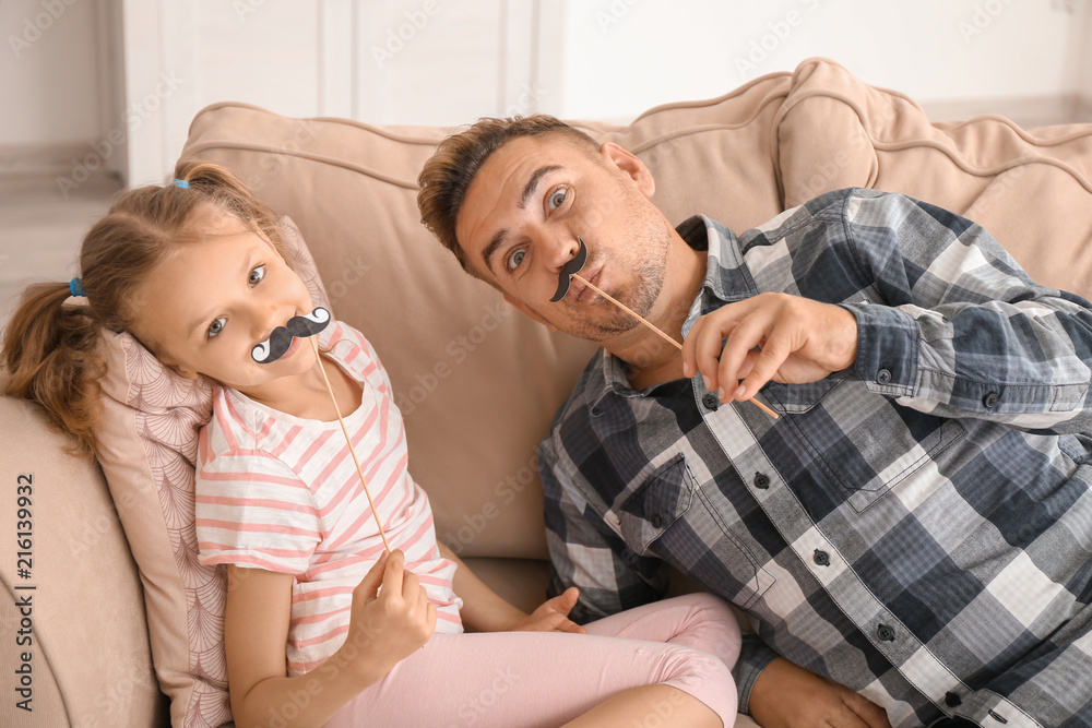 Father and daughter playing with party decor at home