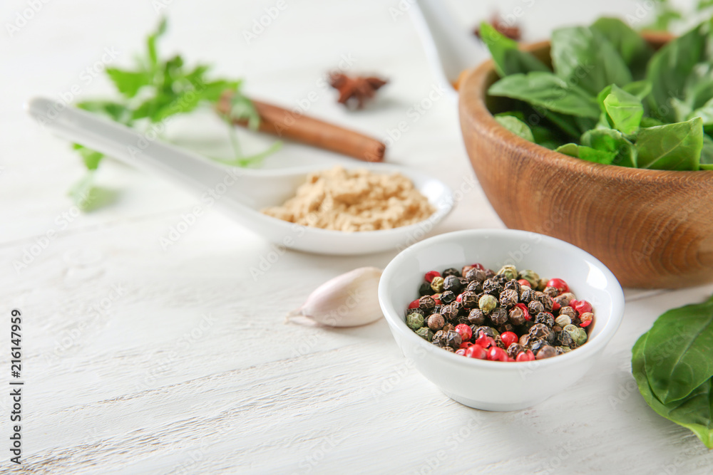 Composition with different spices and herbs on white wooden background