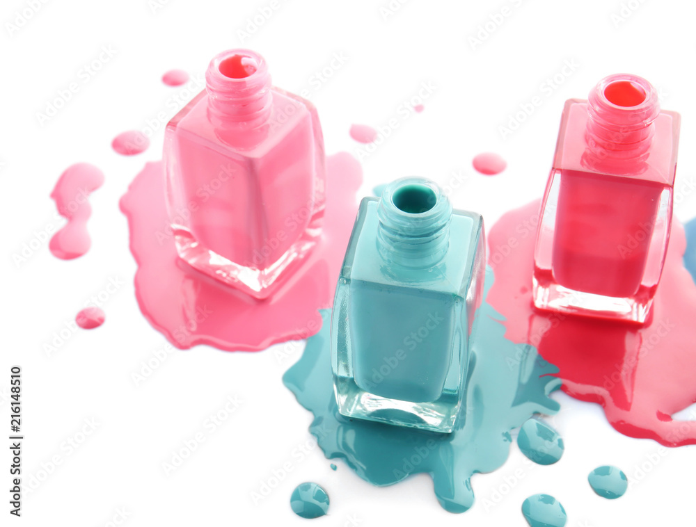 Open bottles of nail polishes on white background