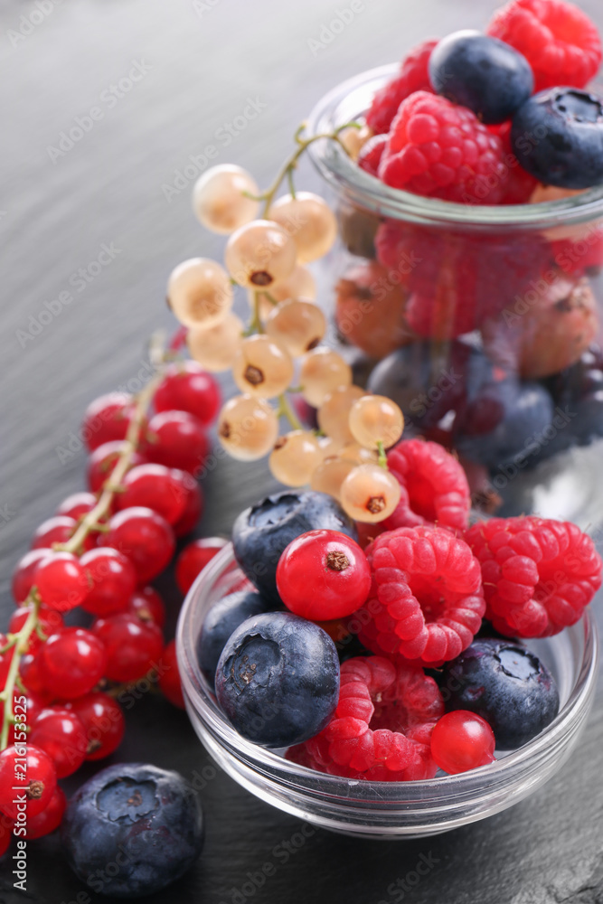 Bowl with different ripe berries on table