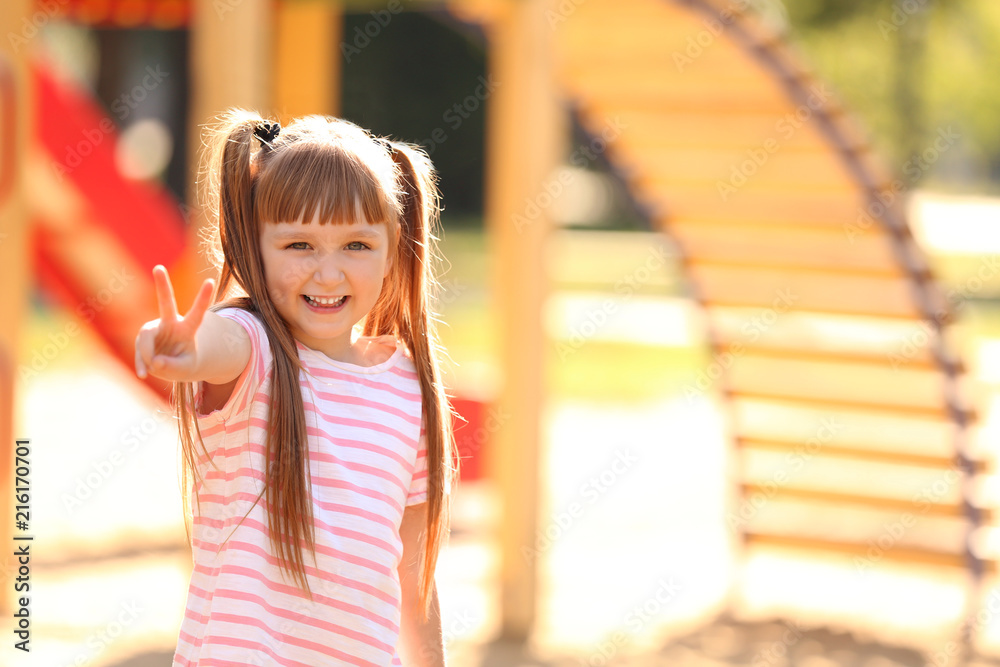 Portrait of cute little girl outdoors on sunny day