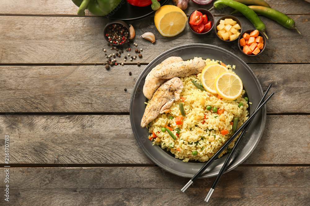 Tasty boiled rice with meat and vegetables on plate