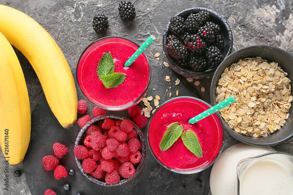 Glasses with tasty raspberry smoothie and products on table