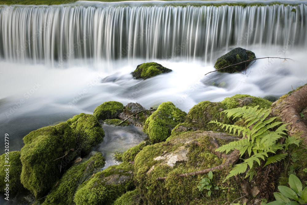 Beautiful waterfalls with mossy rocks background. Long exposure used. Kamnik Bistrica, Slovenia.