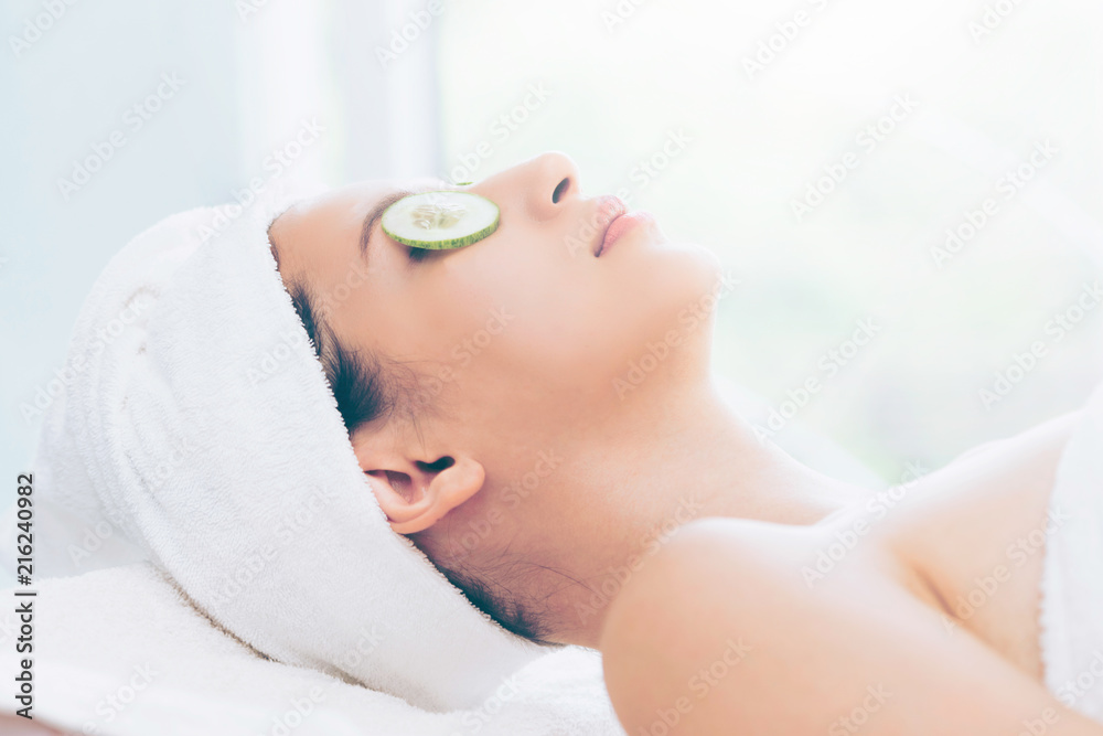 Woman getting eye nature treatment by cucumber.