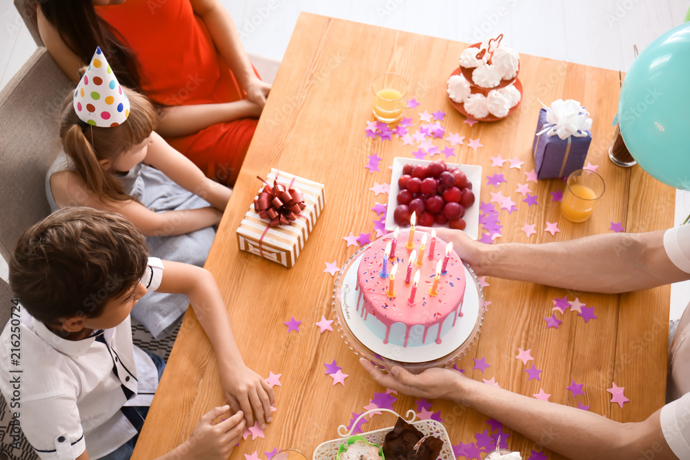 快乐的一家人在餐桌上用蛋糕庆祝生日