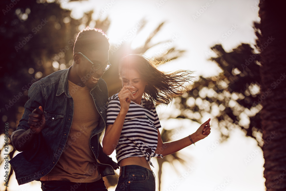 Couple of friends dancing outdoors