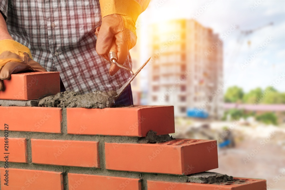 Worker builds a brick wall