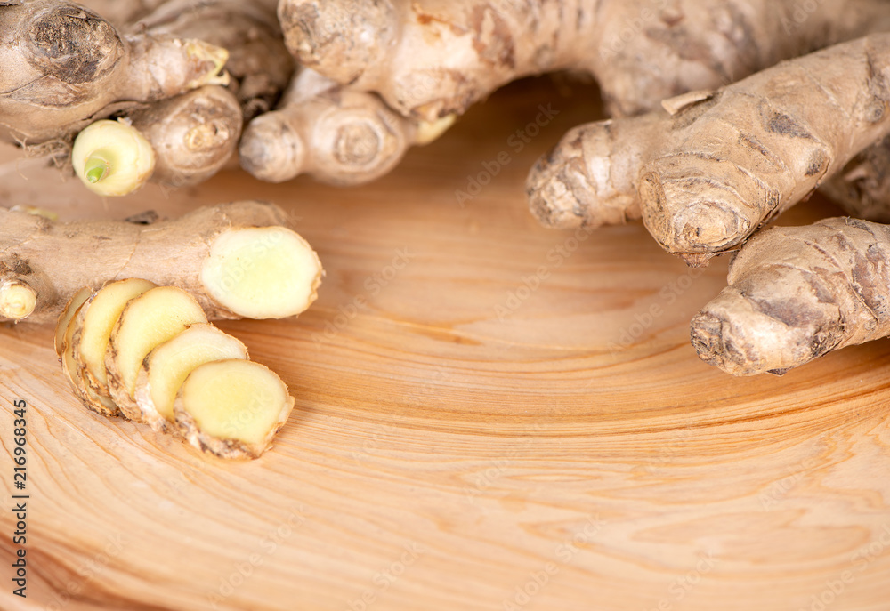 Ginger root, ginger slice and ginger powder on wooden background table, space for text.