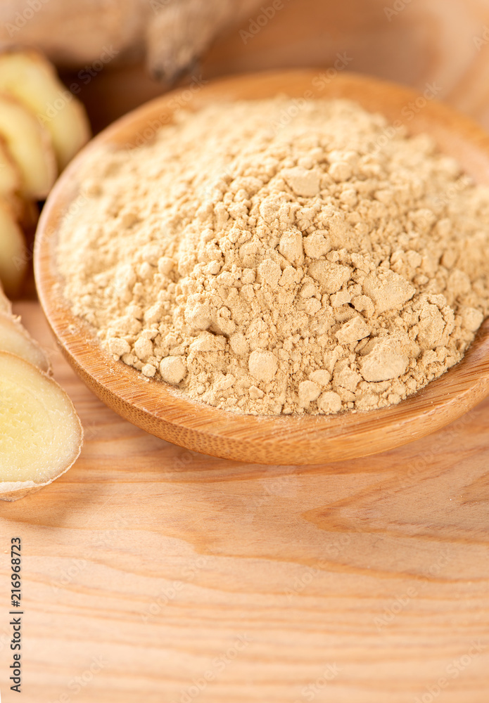 Ginger root, ginger slice and ginger powder on wooden background table, space for text.