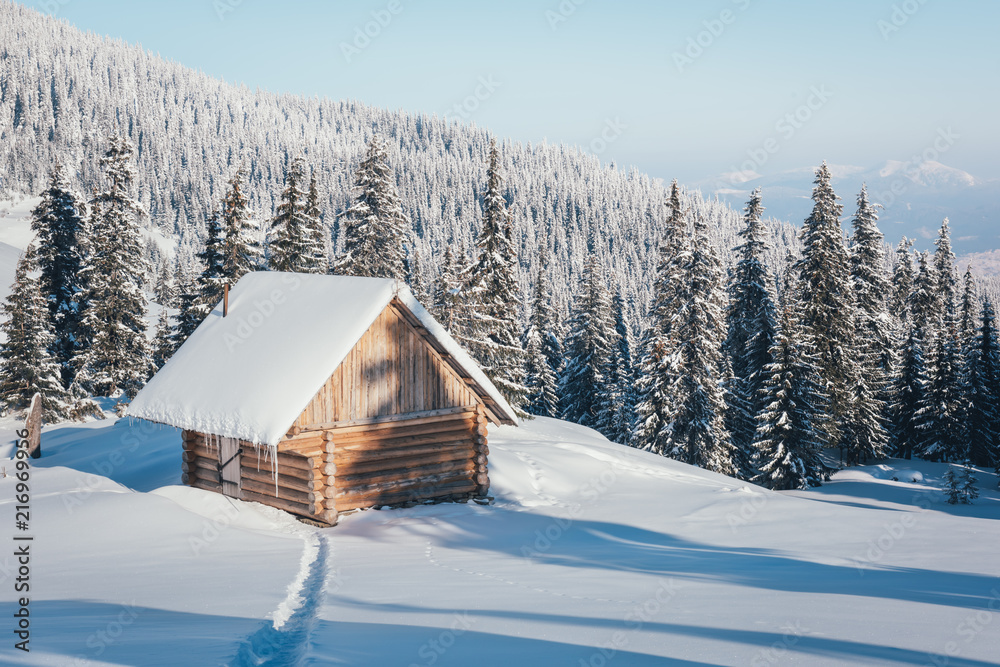 Fantastic winter landscape with wooden house in snowy mountains. Christmas holiday concept. Carpathi