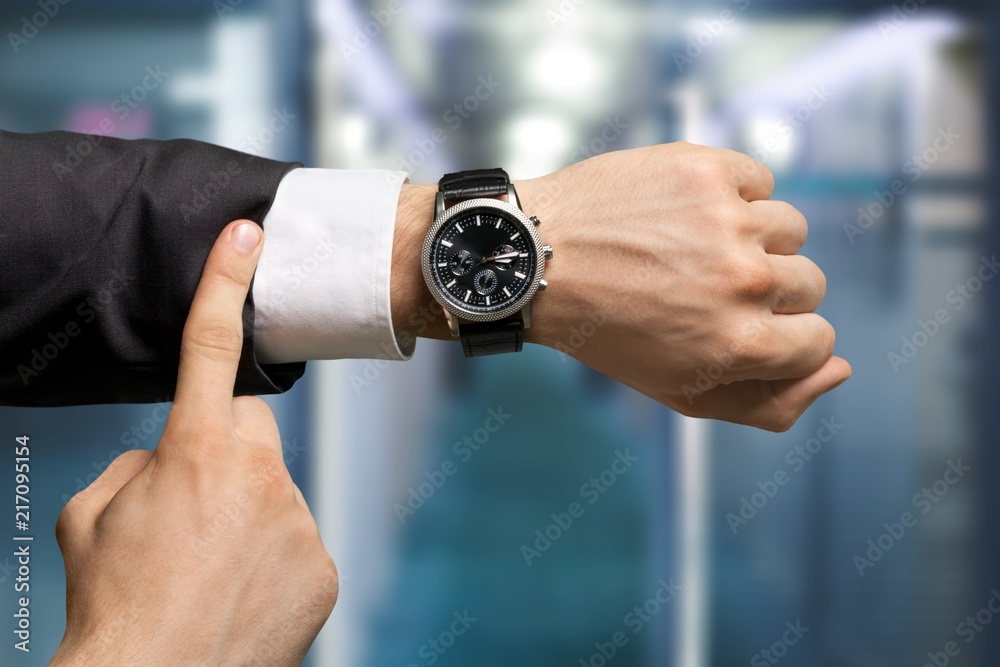 Businessman pointing at hand watch