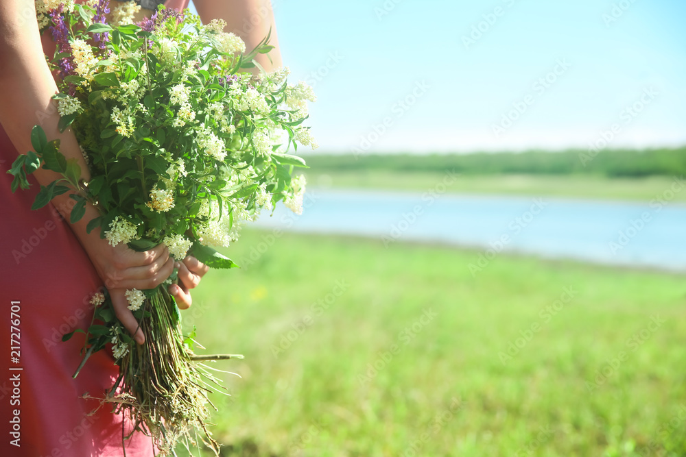 年轻女子在户外捧着一束美丽的鲜花