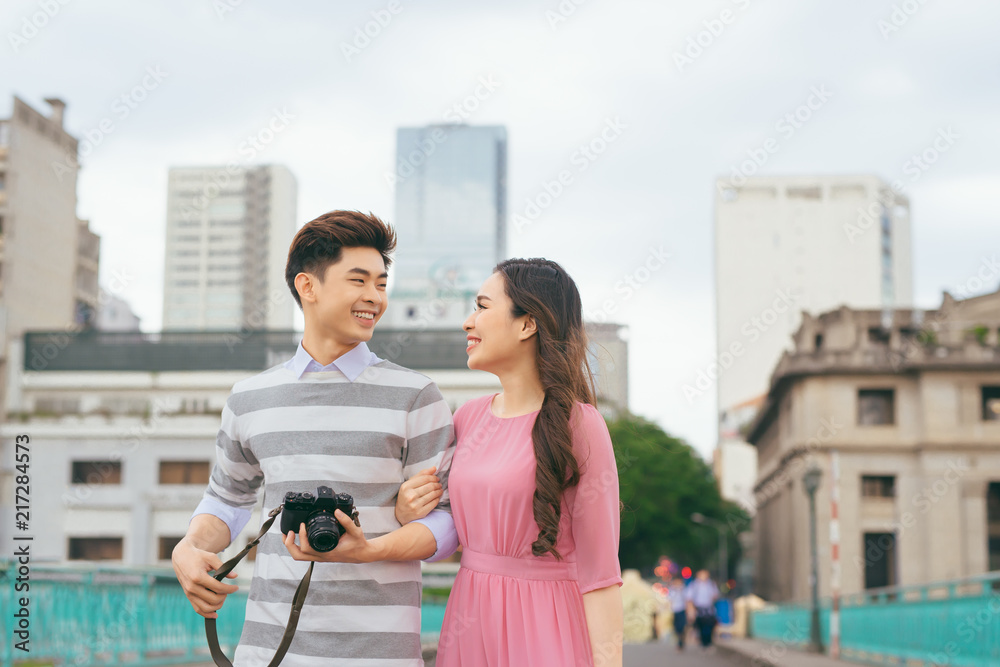 年轻的情侣们在度假时在城市里漫步，一起享受户外旅行。