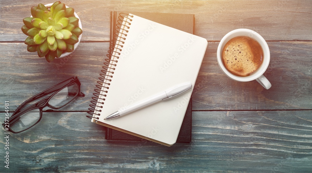 Notebook and cup of strong coffee on