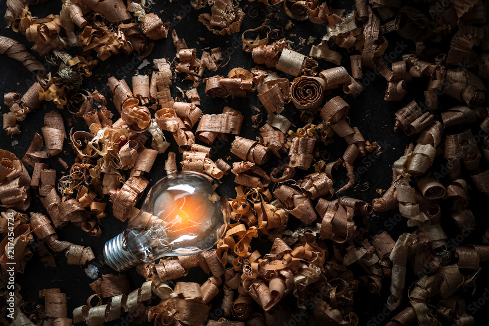 creativity ideas concept with light bulb and wood sawdust on black stone table  vintage color tone