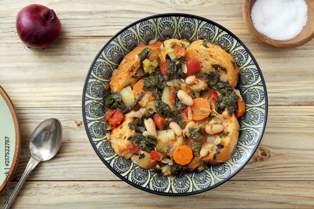 zuppa o minestra di pane con verdure su tavolo di legno