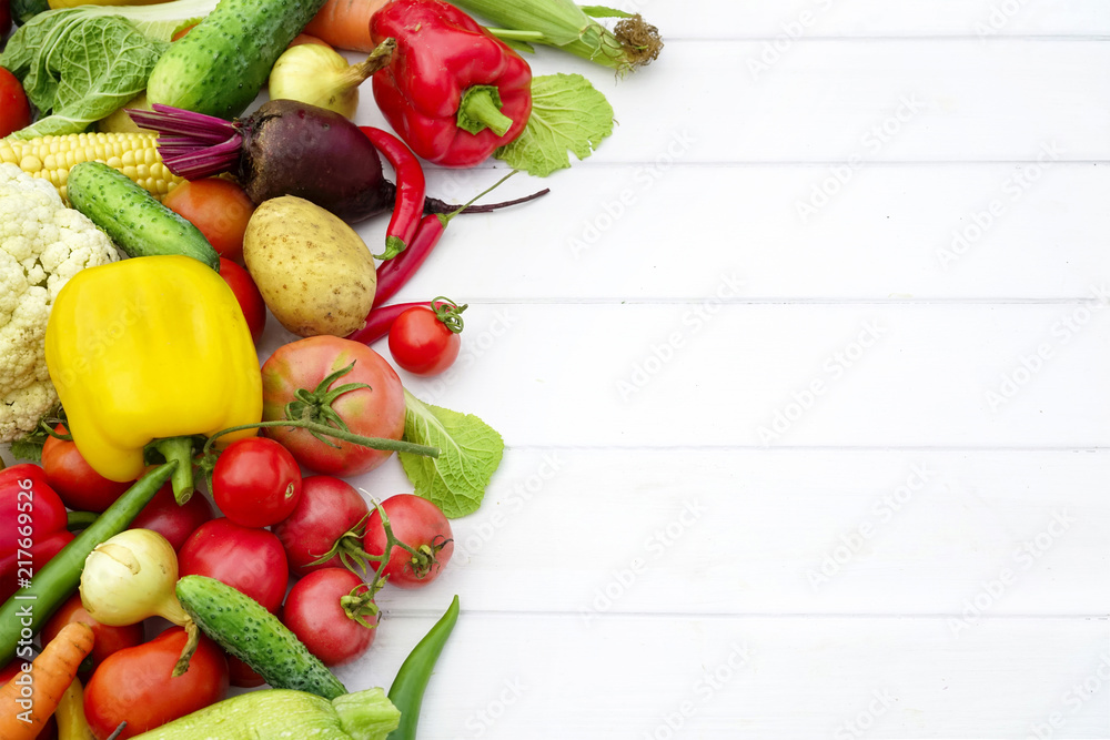 Сomposition of fresh vegetables on white wooden table. Assortment of vegetables, potatoes, cucumbers