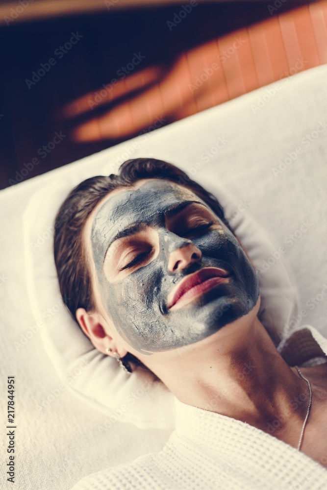 Woman relaxing with a facial mask at the spa