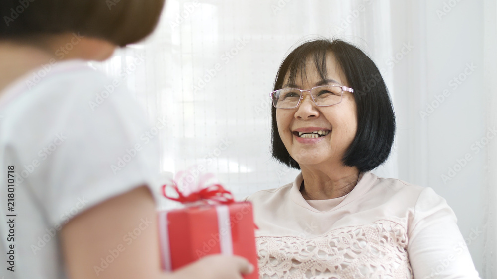 Lovely Asian girl give spacial gift box to her grand mother