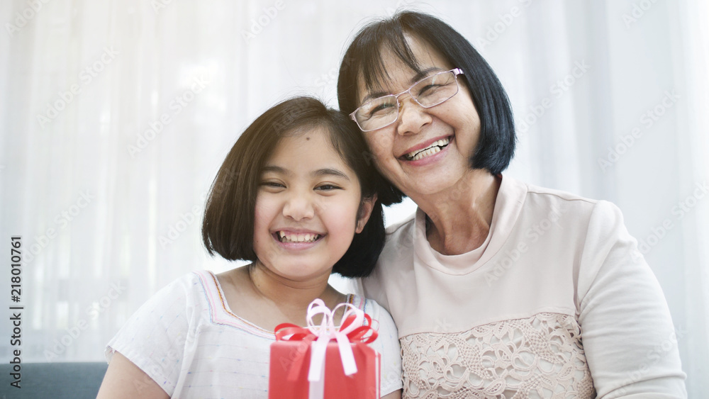 Lovely Asian girl give spacial gift box to her grand mother