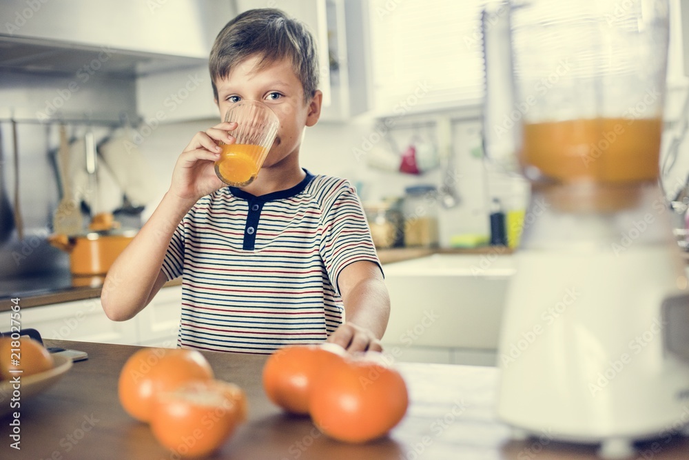 Young Caucasian boy drinking orange juice