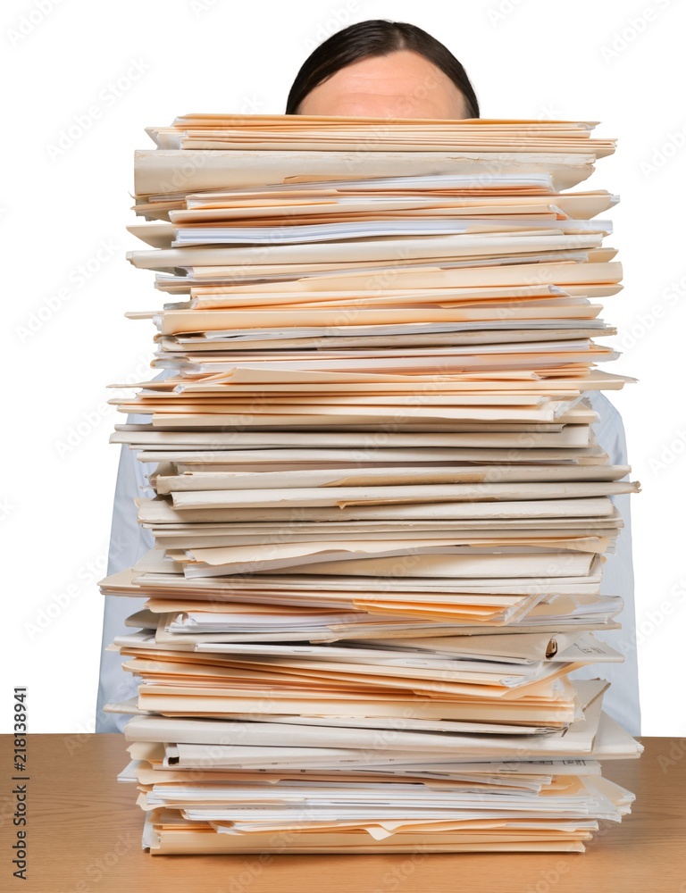 Young overworked manager at workplace with stacks of documents