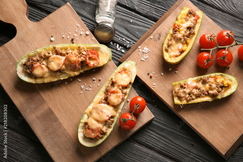 Meat stuffed zucchini boats on wooden table