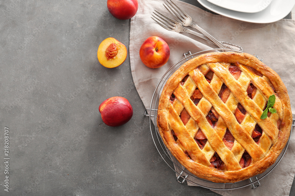 Cooling rack with delicious peach pie on table