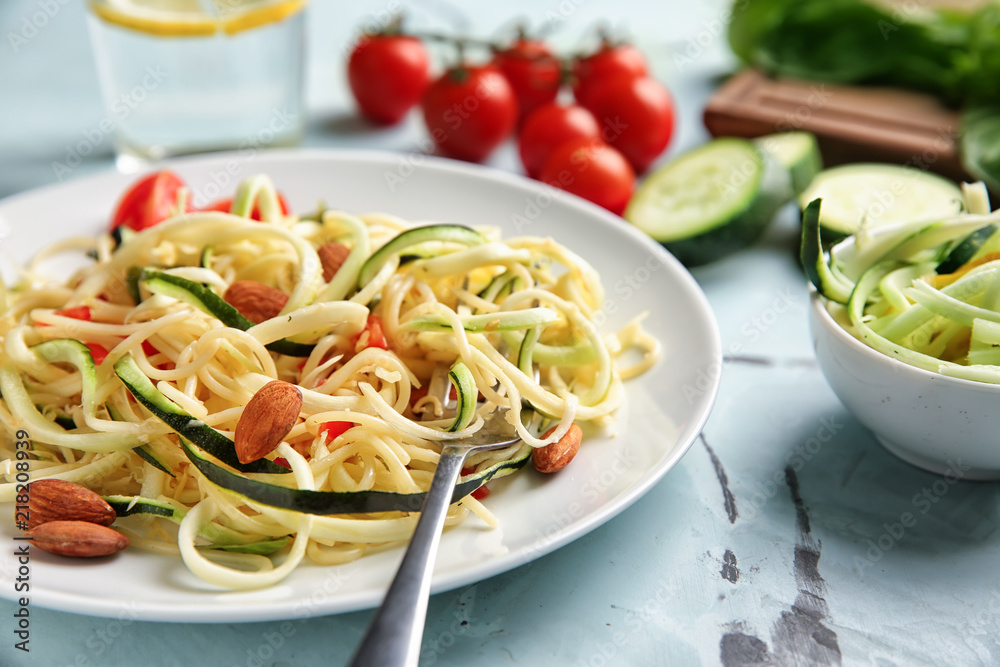 Plate of spaghetti with zucchini on table, closeup