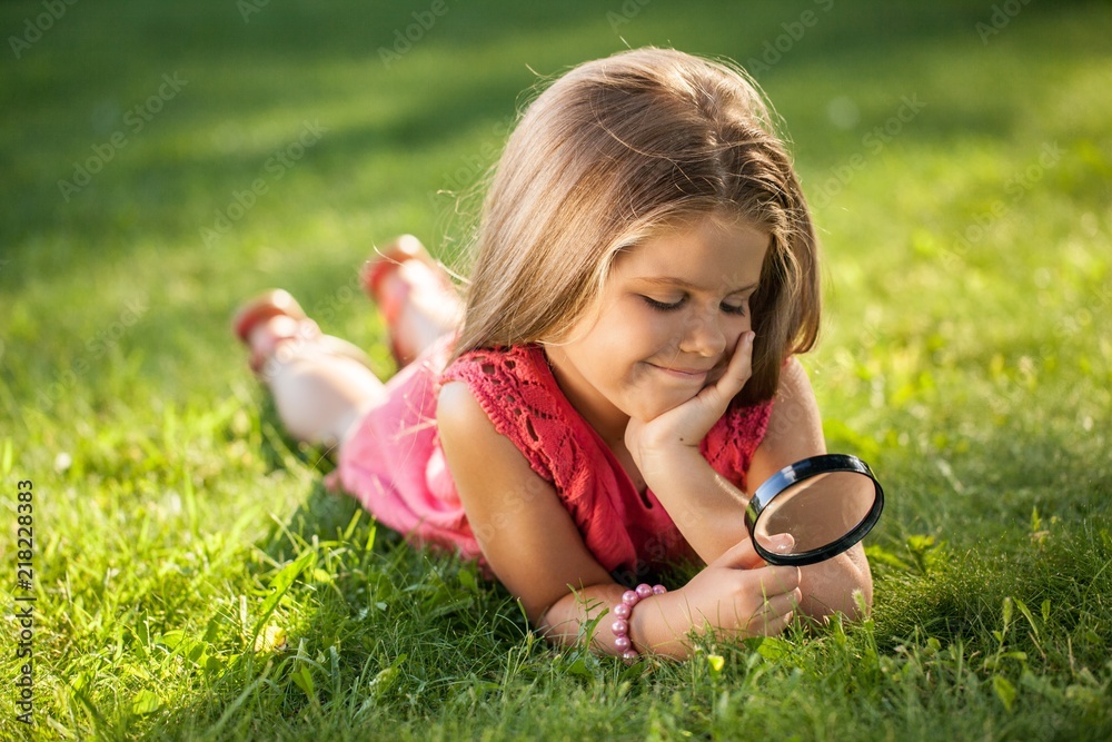 Portrait of a Little Girl Looking Grass with Magnifying Glass