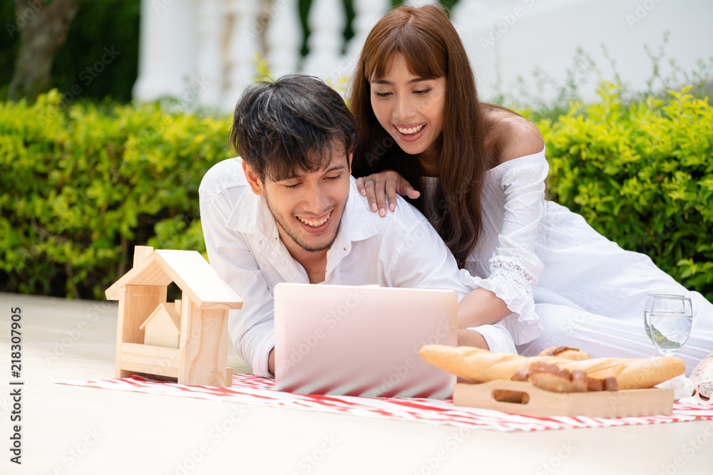 年轻夫妇夏天去公园野餐。