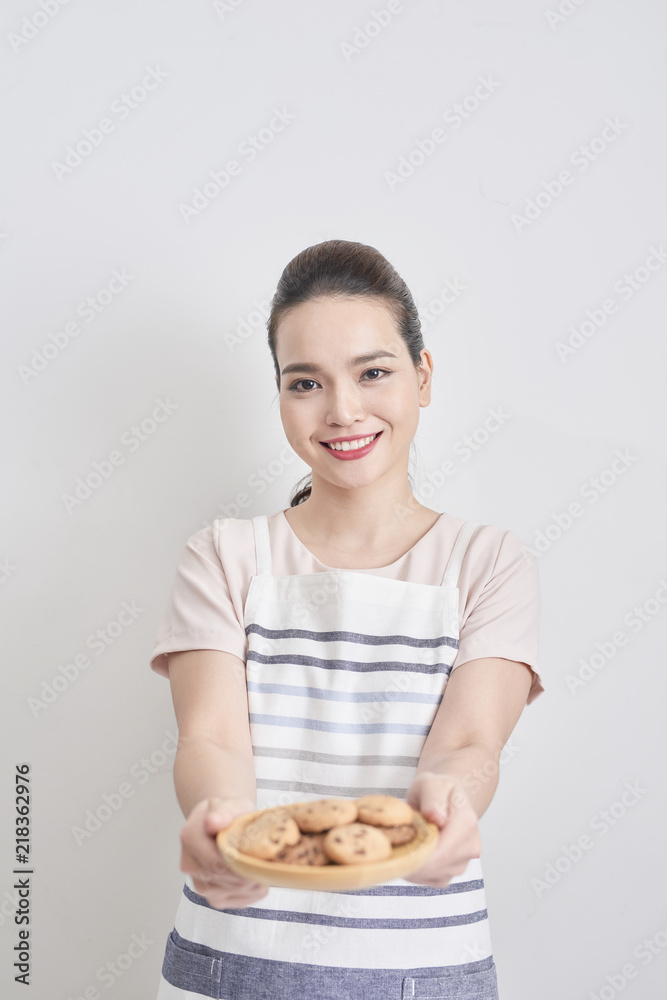 年轻女子拿着一盘自制巧克力饼干