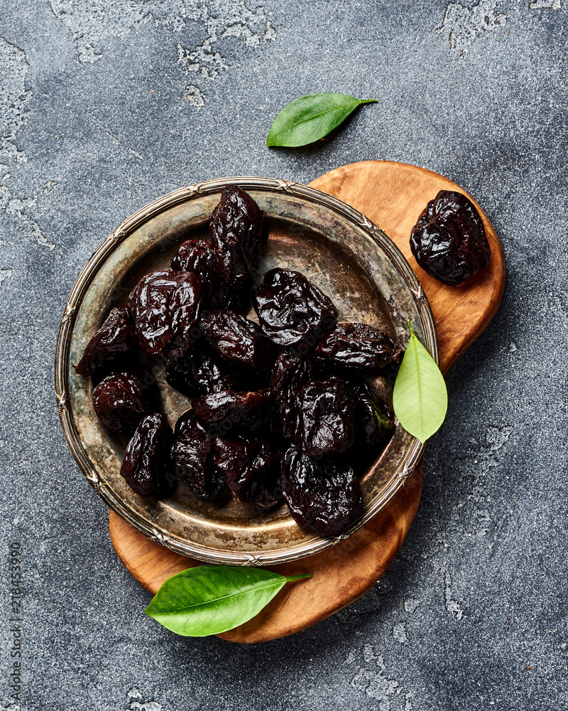 Dried prunes on plate. Top view of peeled plums. Top view.