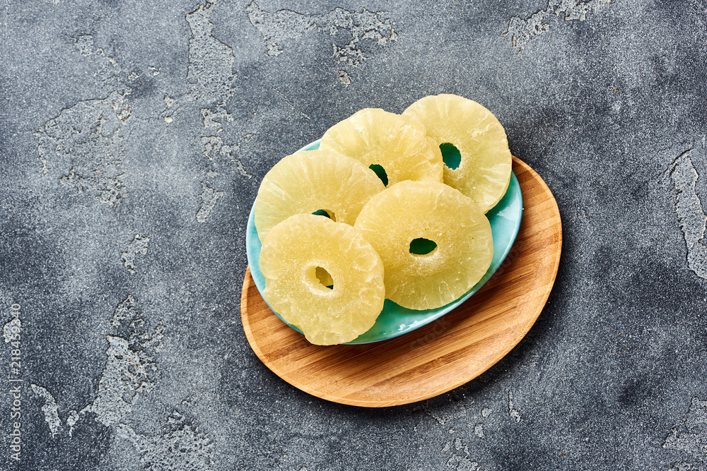 Dried pineapple rings on a gray table. Top viw of sweet paneapple slices.