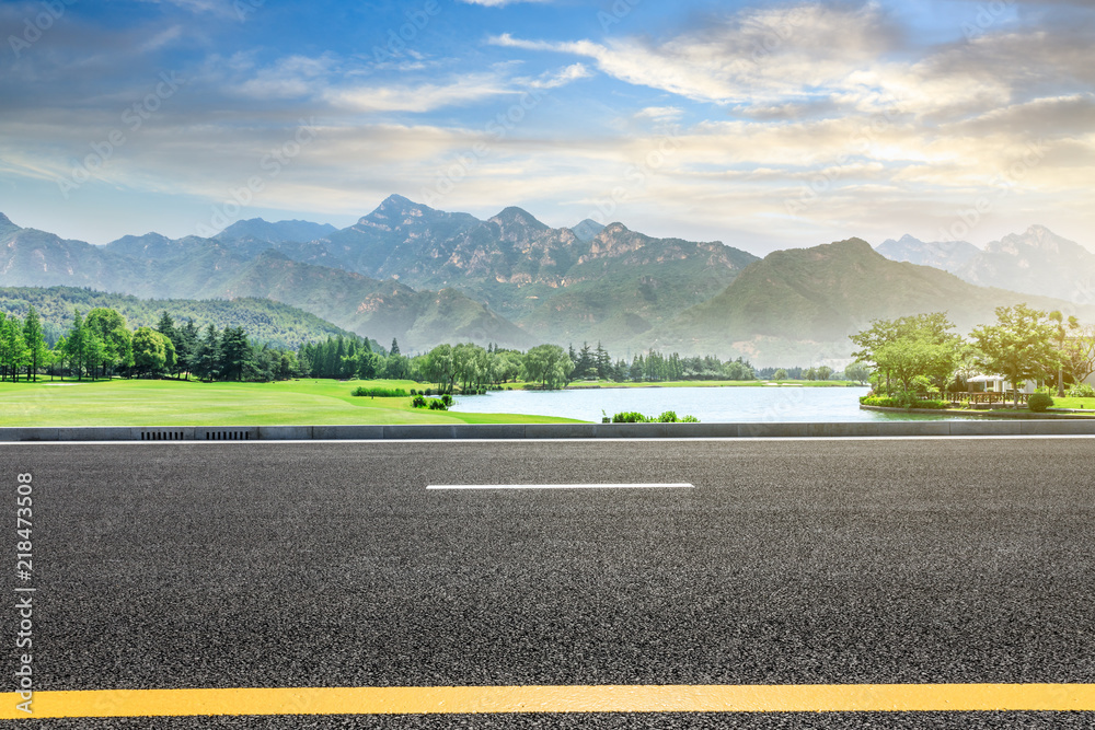 空旷的柏油公路和日落时的青山自然景观