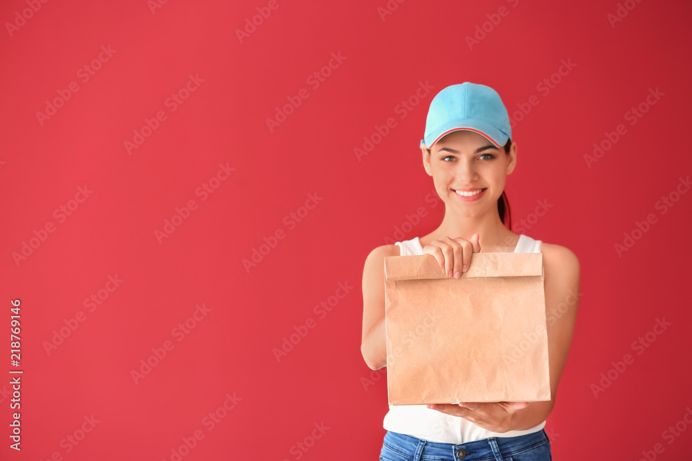 Young woman with paper bag on color background. Food delivery service