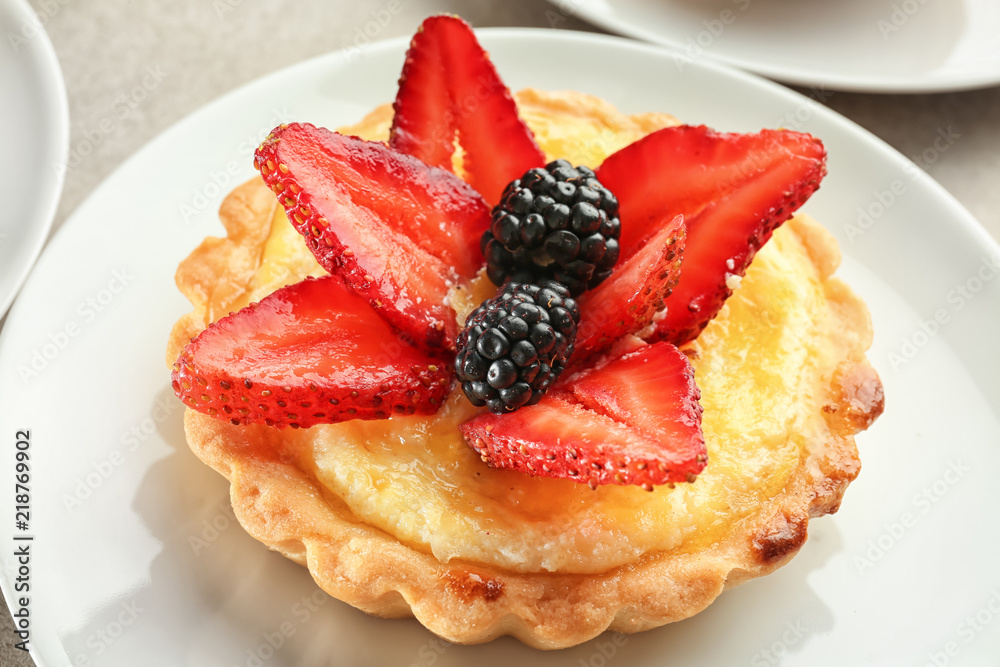 Tasty tartlet with berries on plate, closeup