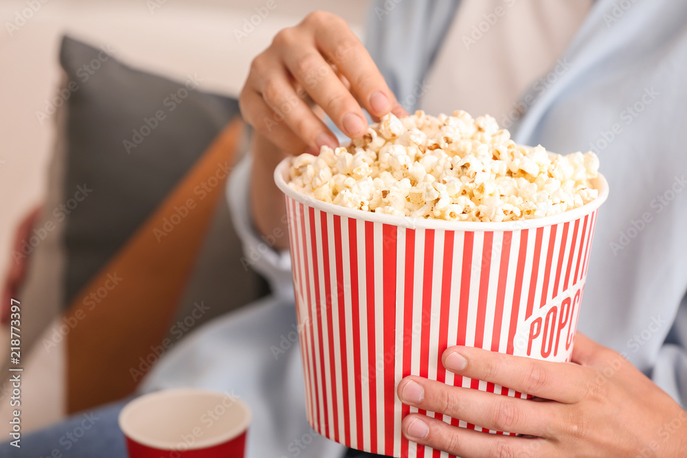 Couple eating popcorn at home, closeup