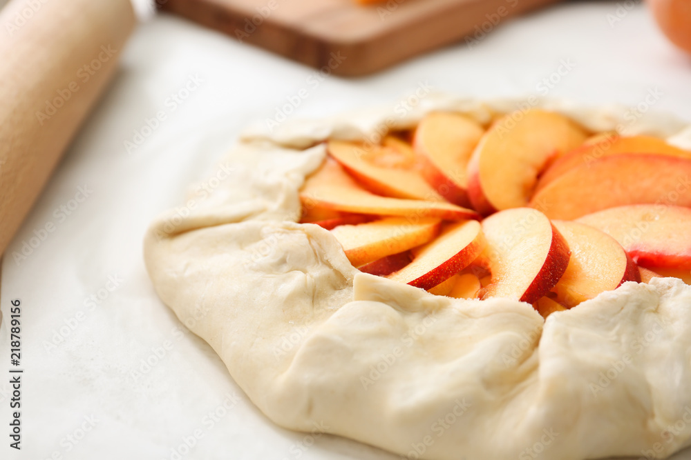 Raw peach galette on table, closeup