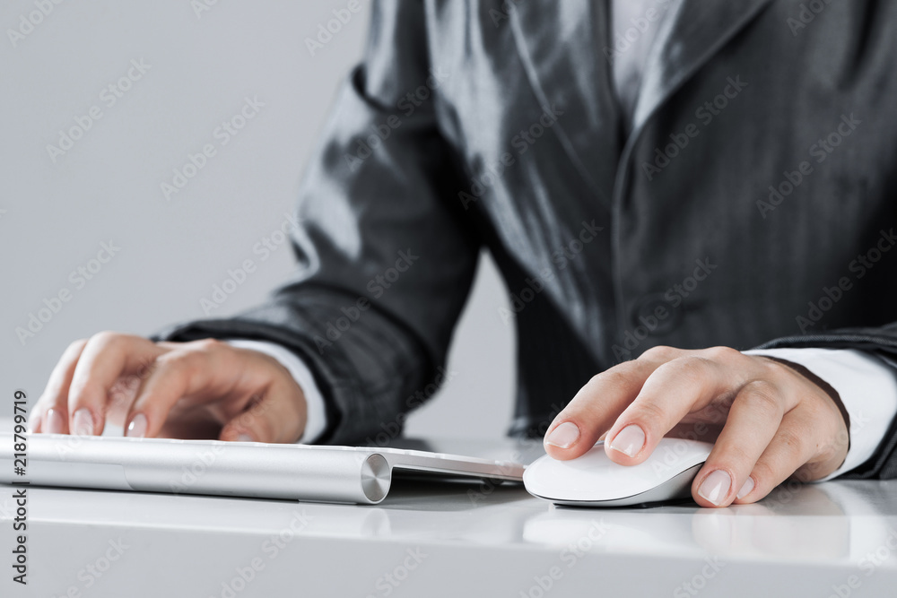 Closeup of businesswoman hand typing on keyboard with mouse on w