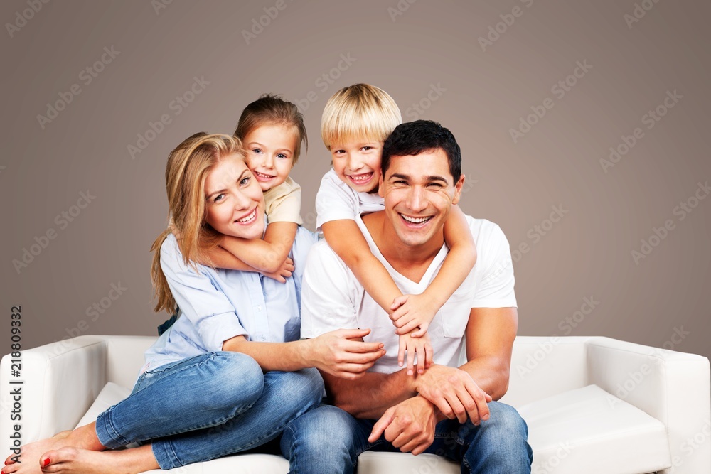 Beautiful smiling family sitting at sofa at home